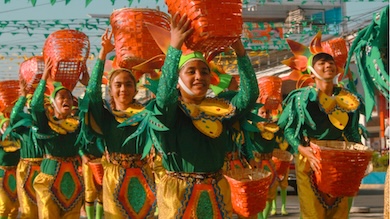 Vibrant street dancers in colorful costumes performing at a Philippine festival, celebrating culture and tradition through music and dance.